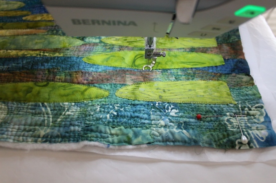 Sewing down the lilypads. The water will be stitched further